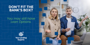 Concerned couple on a sofa with laptop and papers, in a bright room, beside text: Don’t fit the bank’s box? Loan options.